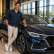 Jovem ao lado do carro novo