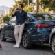 Motorista ao telefone ao lado do carro após pequena batida